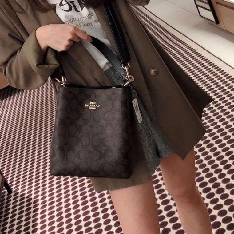 COACH 2312 SMALL TOWN BUCKET BAG IN SIGNATURE CANVAS รุ่นยอดนิยมใบเล็กมาครบสีแล้วจ้า กระเป๋าทรงบัคเก็ต สีผู้ดี๊ผู้ดี ตัวกระเป๋าดีไซน์คลาสสิคลายซี ดูโดดเด่น วัสดุหนังแคนวาสเคลือบลาย สวยคมทุกมุมจริงๆ!! เปิด-ปิดด้วยกระดุมแม่เหล็กทั้ง 2 ฝั่ง ภายในเป็นช่องโล่ง