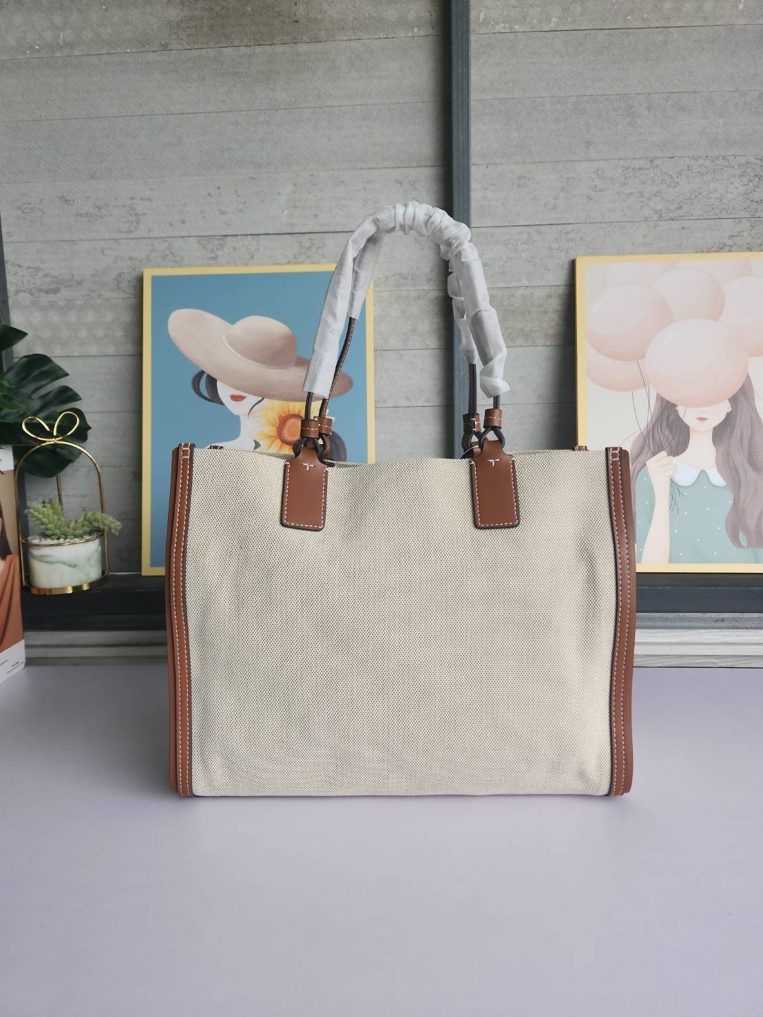 TORY BURCH ELLA CANVAS TOTE BAG กระเป๋าโท้ตน้ำหนักเบาของเราพร้อมป้ายโลโก้ Ella ทำจากผ้าใบที่ทนทานพร้อมรายละเอียดหนังและกระเป๋าด้านใน อเนกประสงค์ ทรงคลาสสิก และสร้างขึ้นอย่างสวยงามด้วยฝีมือช่างฝีมือ สายรัดแคบช่วยให้วางราบกับไหล่ได้อย่างสบาย เหมาะสำหรับทุกว