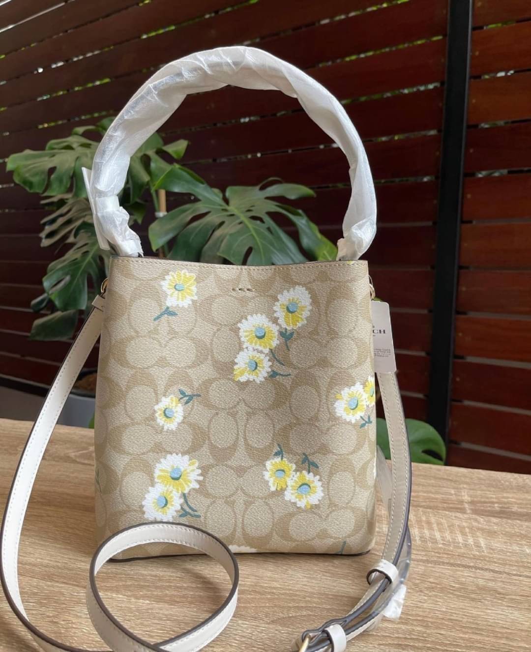 OUTLET 】COACH C3411 SMALL TOWN BUCKET BAG IN SIGNATURE CANVAS WITH DAISY PRINT สวยสดใสมาให้ถึงบ้านจ้า!! กระเป๋าทรงบัคเก็ตยอดฮิต รอบนี้น่ารักมุ้งมิ้งไม่เลิก ดีไซน์ลายดอกเดซี่คละรอบใบ วัสดุหนังแคนวาสเคลือบลาย ปากกระเป๋าเปิด-ปิดด้วยกระดุมแม่เหล็ก 2ฝั่ง มีหูจ