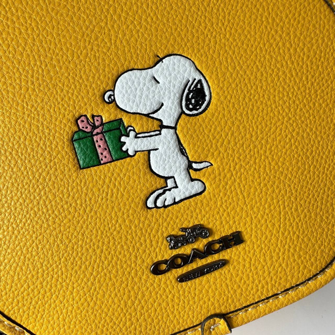 COACH X PEANUTS CANTEEN CROSSBODY WITH SNOOPY PRESENT MOTIF (CE845,CF290) กระเป๋าสะพายข้างทรงกลมไซส์มินิ มีหูจับ วัสหนังแท้ ด้านหน้าโดดเด่นด้วยรูปการ์ตูนSnoopy