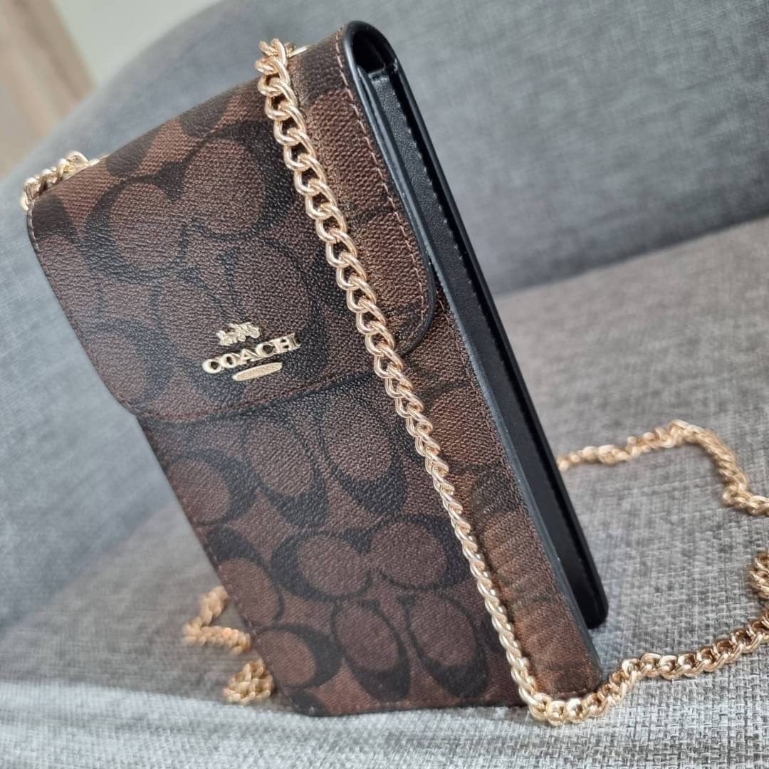 COACH NORTH/SOUTH PHONE CROSSBODY IN SIGNATURE CANVAS F55636 F39955 สุดคลาสสิคกับกระเป๋าสะพายเอนกประสงค์ Case phone ใส่โทรศัพท์มือถือได้ทุกรุ่น ดีไซน์ลายเอกลักษณ์ วัสดุหนังแคนวาสเคลือบลาย ฝาและภายในเป็นหนังสังเคราะห์เรียบ เปิด-ปิดด้วยกระดุม สายสะพายยาวประ