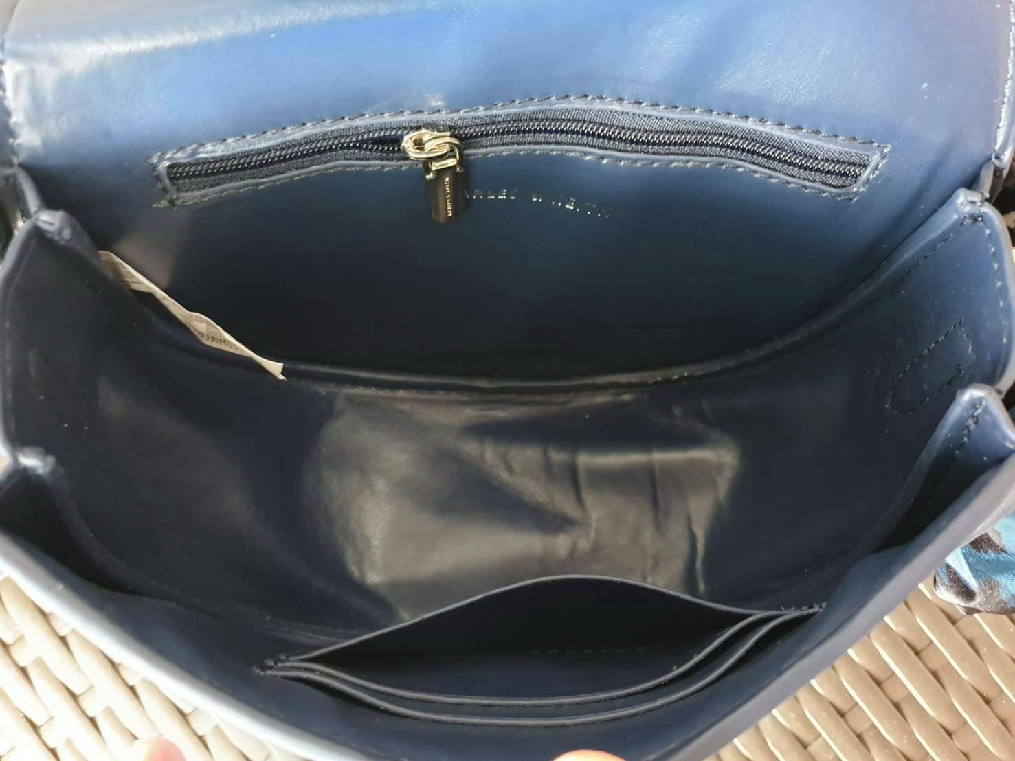 CHARLES & KEITH รุ่น LEATHER SATIN SCARF CROSSBODY BAG SL2-50150828 ราคาปกติช้อป ( ฿3,590.00 ) กระเป๋าถือ และ สะพาย ทรงโค้งมน หนังเรียบ ตั้งอยู่ทรง ด้านหน้าติดโลโก้แบรนด์ อะไหล่เงิน หูจับสายกระเป๋าร้อยเข้ากับห่วงเหล็กกลมๆ ด้วยผ้าลายสวยงามผูกเป็นโบว์เก๋ๆ ถ