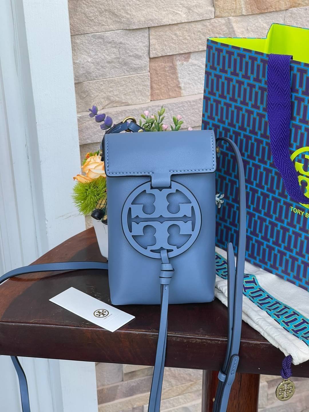 TORY BURCH MILLER METAL PHONE CROSSBODY อีกหนึ่งกระเป๋าใส่มือถือรุ่นฮิตที่เชื่อว่าหลาย ๆ คนต้องเคยเห็นผ่าน ๆ ตามาอย่างแน่นอน กับแบรนด์ Tory Burch ดีไซน์กระเป๋าทรงฝาพับแม่เหล็กใช้งานง่าย มาพร้อมดีเทล Logo สีเดียวกับเฉดสีของกระเป๋า แต่ยังมีความน่ารักด้วยทรง