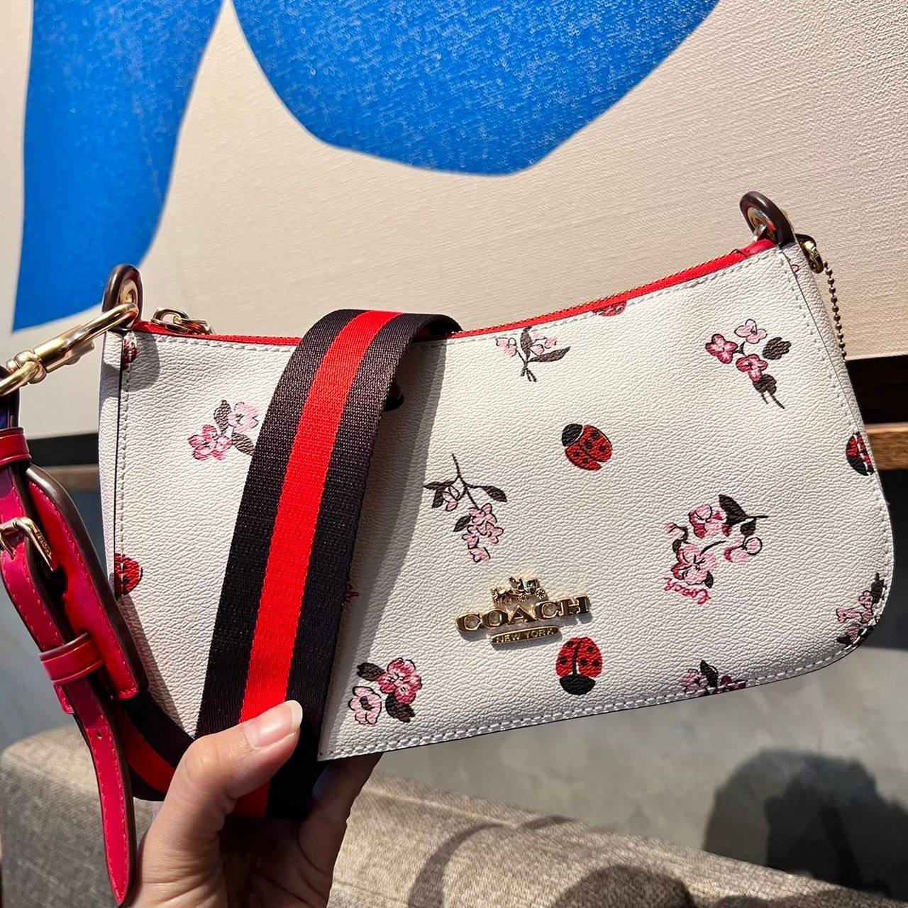COACH C7973 JES BAGUETTE WITH LADYBUG FLORAL PRINT คอลเลคชั่นใหม่ล่าสุด พร้อมเสิร์ฟความสวยถึงบ้านเช่นเคย!! กระเป๋าสะพายทรงบาแกตต์ ดีไซน์ย้อนยุค ที่แอบแฝงความเรียบหรูดูแพงอยู่ในตัว โดดเด่นด้วยสายสะพายเส้นใหญ่ โทนสีคอนทราส ทำให้ไอเท็มนี้ดูมีลูกเล่นมากขึ้น ว
