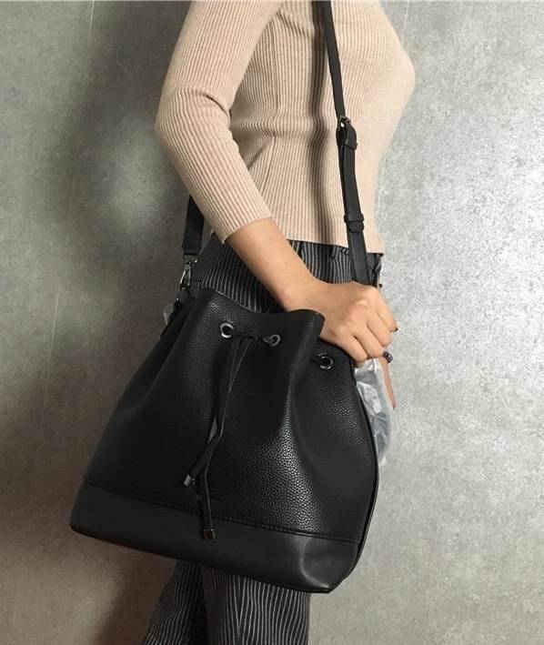 GUESS. DRAWSTRING BUCKET BAG WITH STRAP กระเป๋าถือหรือสะพายแบรนด์ดังรุ่นยอดนิยม วัสดุหนังแกะสังเคราะห์แบบนิ่มสวยอยู่ทรง ด้านหน้าประดับโลโก้ เปิดปิดแบบ Drawstring มาพร้อมสายสะพาย 2แบบ ทั้งสายสั้นสะพายไหล่และสายยาว crossbody ปรับระดับได้ ภายในกว้างมีช่องซิป