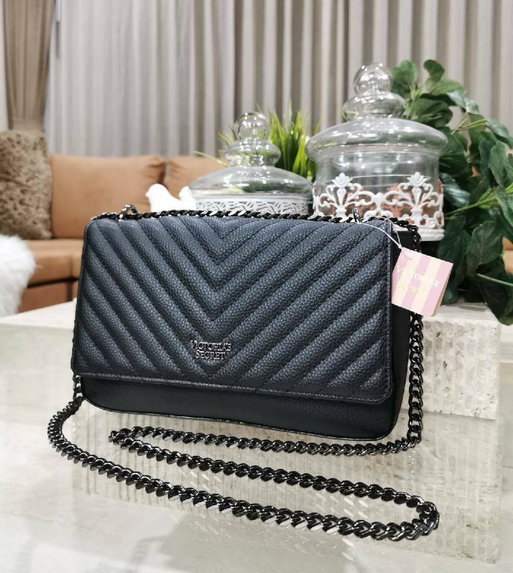 VICTORIA'S SECRET Quilted Chain Crossbody Sling Bag กระเป๋าสะพายรุ่นใหม่ล่าสุดจาก Victoria's Secret วัสดุหนังแกะสังเคราะห์ชึ้นลายริ้วหนังสวยอยู่ทรงไม่ย้วยดีไซน์สุดหรูคุณหนูไฮโซ เปิดปิดด้วยฝาปิดกระดุมแม่เหล็ก ภายในมีโลโก้และช่องใส่ของ ใส่กระเป๋าส