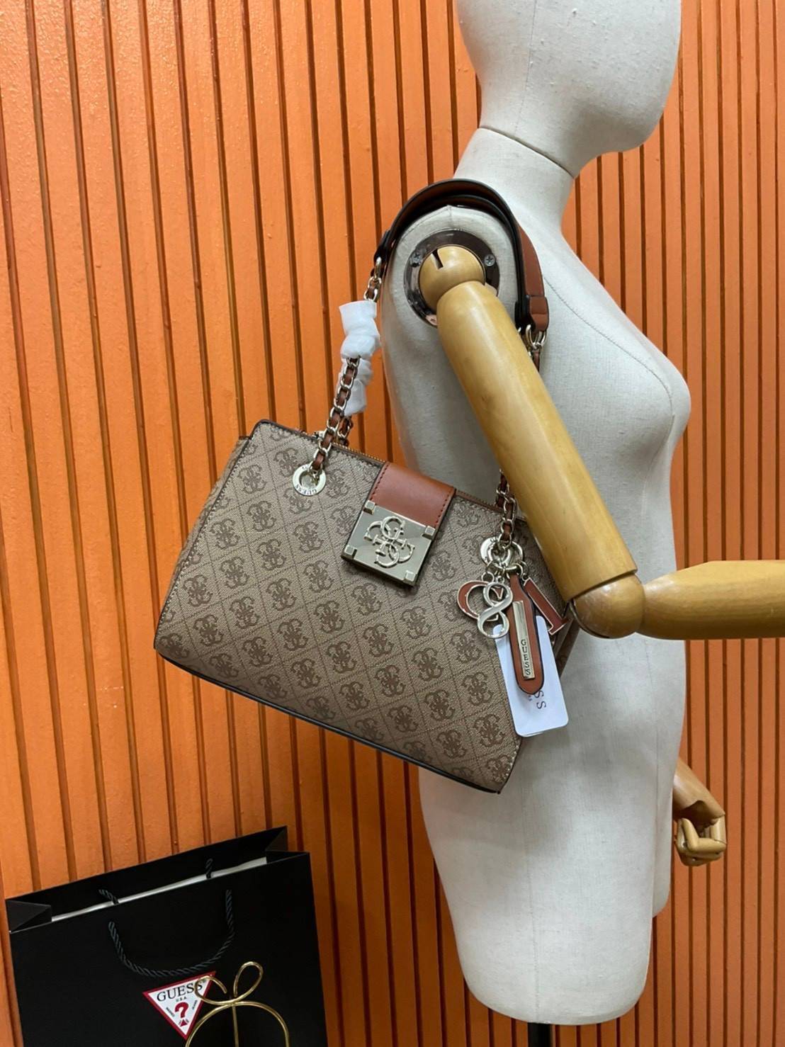 กระเป๋าสะพายไหล่ Guess Logo City Small Society Satchel กระเป๋าสะพายไหล่ ขนาดกำลังดี วัสดุ pu สวยอยู่ทรง มาพร้อมพวงกุญแจน่ารักๆ ถอดออกได้ ด้านหน้าประดับโลโก้แบรนด์ เปิดปิดด้วยซิป มี 2 ช่องหลักใช้งาน ภายในช่องซิปหน้าแยกเป็นสัดส่วนการใช้งาน ซิปช่อง 2 โล่งกว้