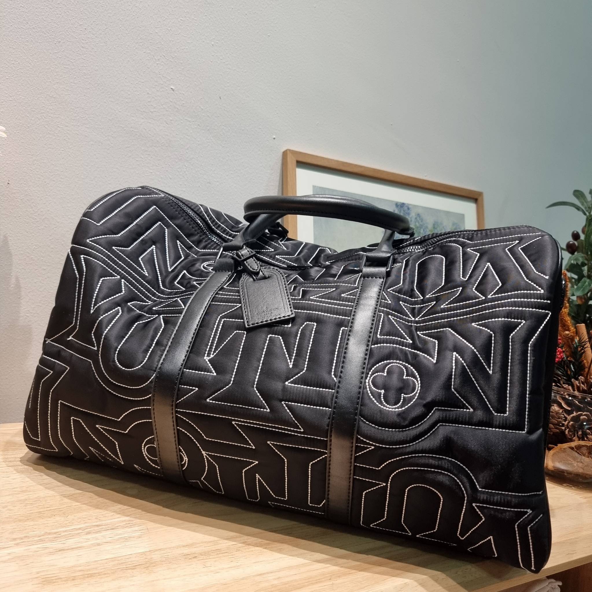 LV KEEPALL 50B SNOW BAG กระเป๋าเดินทางสุดคลาสสิค ประจำฤดูกาล Winter 2022 สไตล์สปอร์ต ทึ่ใครๆก็เฝ้ารอ ไอเท็มที่จะทำให้การเดินทางไม่ธรรมดาอีกต่อไป ด้วยดีเทลความเป็นเอกลักษณ์ เรียบแต่หรู ดีไซน์ลายปักความเป็นเอกลักษณ์ผสาน ลวดลายโมโนแกรมฟลาวเวอร์ ลงบนผ้าไนลอนร