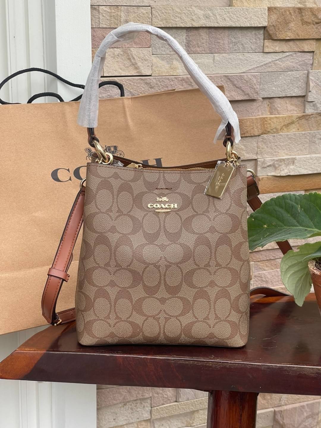 COACH SMALL TOWN BUCKET BAG IN SIGNATURE สำหรับสาวแฟชั่นที่ชอบรายละเอียดชิคๆ ดีไซน์สุดเก๋ แนะนำเลยสำหรับกระเป๋าทรงบักเก็ตใบนี้ เชื่อว่าสาว ๆ หลายคนชื่นชอบ เป็นไอเทมที่สามารถแมทช์ได้กับเสื้อหลากหลายสไตล์ บรรจุของได้เยอะโดยที่กระเป๋าไม่เสียทรง แบ่งช่องใช้งา