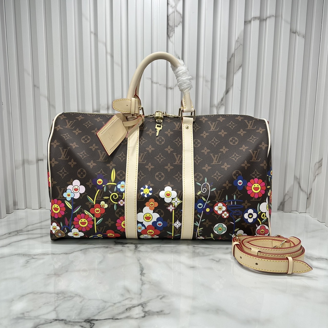 LV x TM Keepall Bandoulière 45 Bag Monogram Flower กระเป๋าเดินทางคอลเลกชันสุดพิเศษ สวยคลาสสิกมีชีวิตชีวา สีสันสดใสสไตล์ superflat สุดไอคอนิกของ Takashi Murakami ด้วยโมโนแกรมดอกไม้หลากสี ปรับดีไซน์ให้ดูสนุกสนาน
