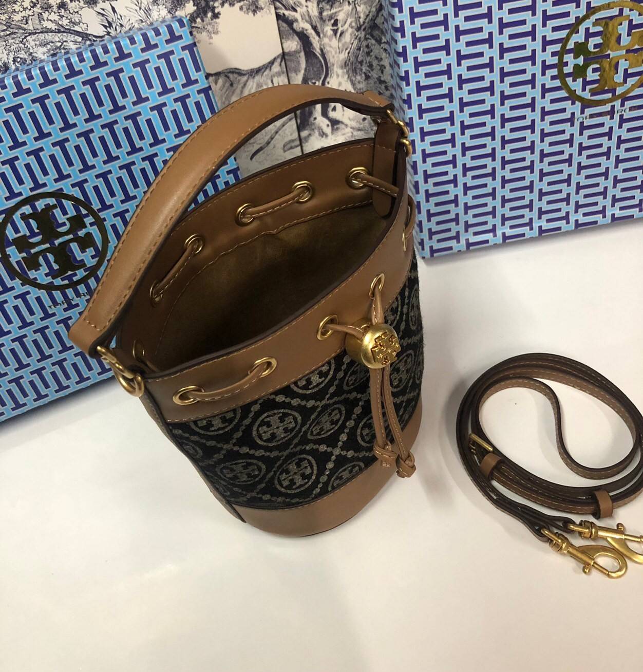 Mini : Tory Burch T Monogram Chenille Bucket Bag เปิดตัวอีกหนึ่งรุ่นกับกระเป๋าลาย T MONOGRAM รุ่นใหม่ล่าสุดจาก TORY BURCH พลาดไม่ได้กับโลโก้สุดคลาสสิก ลวดลาย T Monogram คือวัสดุ chenille หรือที่เรียกว่า ด้านไหมกำมะหยี่ มารังสรรค์ลงบนกระเป๋าBucketใบนี้ เป็