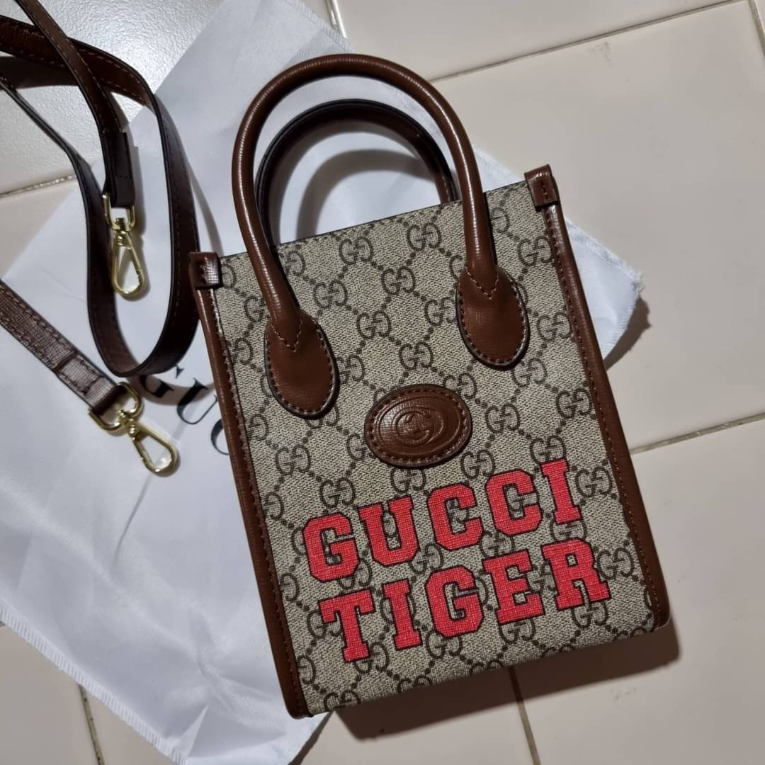 GUCCI Tiger GG mini tote bag ไซส์มินิ ร้อนแรงไฟลุก!! ต้อนรับปีเสืออย่างเป็นทางการ จัดให้แบบเลิศๆ กับกระเป๋าทรงโท้ท วีไอพีพรีเมี่ยมกิ๊ฟ ไซส์มินิ โดดเด่นด้วยฟอนท์ตัวใหญ่ สวยเอกลักษณ์ วัสดุหนังแคนวาสตัดขอบด้วยหนังแท้ ภายในเป็นช่องโล่ง ใส่ของจุกจิกได้ ใส่โทรศ