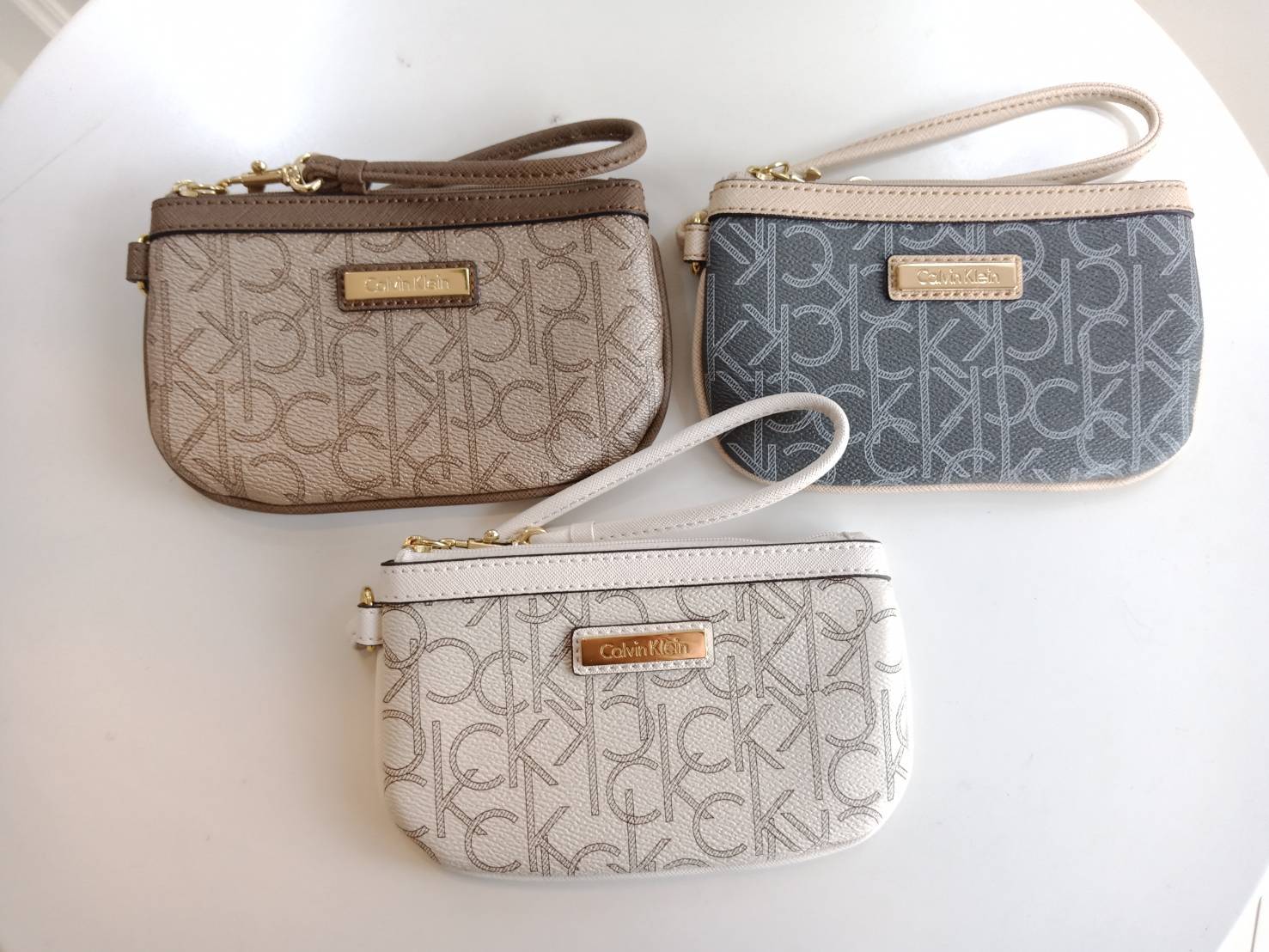 New must have item! กระเป๋าคล้องมือ ทรงน่ารัก จากแบรนด์ calvin klein มีมาให้ช้อปคะ หนัง pvc ทั้งใบอย่างดี มีสายคล้องมือเก๋ ด้านหน้าตกแต่งด้วยโลหะปั้มแบรนด์ เปิดปิดด้วยซิป ด้านในบุด้วยผ้าปั้มแบรนด์ มีช่องใส่บัตรแยก จะใส่ธนบัตรหรือบัตร ก็พกติดตัวในวันสบายๆ 