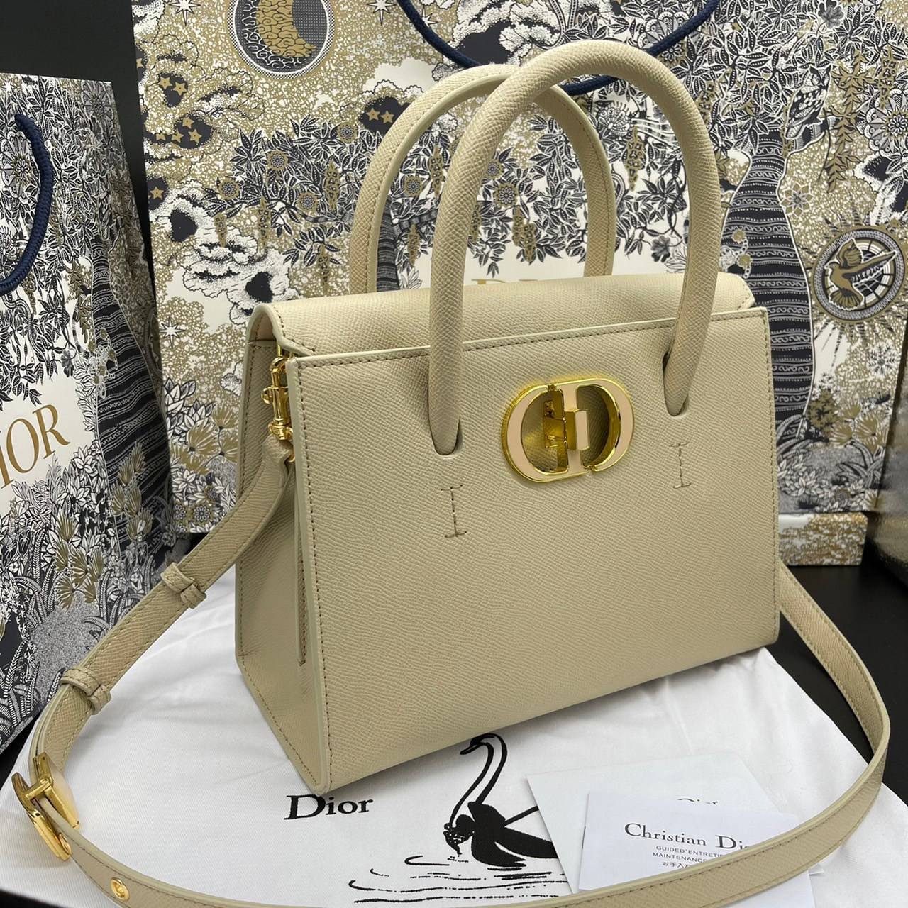 หนังแท้ DIOR Medium ST Honore Tote Collection Fall/Winter 2020-2021 มาในรูปแบบกระเป๋าทรงสี่เหลี่ยมที่ได้มาตรฐาน ทำจากหนังลูกวัว (Calfskin) ลายเกรน ซึ่งสื่อถึงความหรูหราได้อย่างลงตัว ตัวด้ามจับ มีการเย็บเข้าด้านในของกระเป๋าเพื่อเพิ่มความแข็งแรงทนทาน ด้านหน