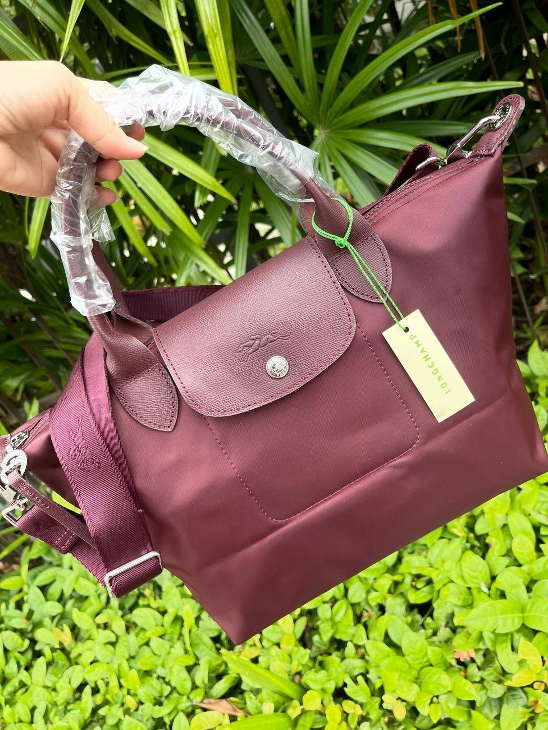 Longchamp LE PLIAGE NÉO TOP HANDLE BAG อีกหนึ่งรุ่นยอดนิยม ที่สาวๆ ต้องมีไว้เก็บไว้สักใบ กระเป๋าโท้ทใบนี้ มาพร้อมกับสีที่มีสไตล์เรียบง่าย มีสายสะพายยาวปรับสั้นยาวได้ช่วยให้คุณสามารถสะพายไหล่ได้อย่างสบาย ในตัวสายปักโลโก้อันเป็นสัญลักษณ์ ในขณะที่ที่ปิดแบบซิ
