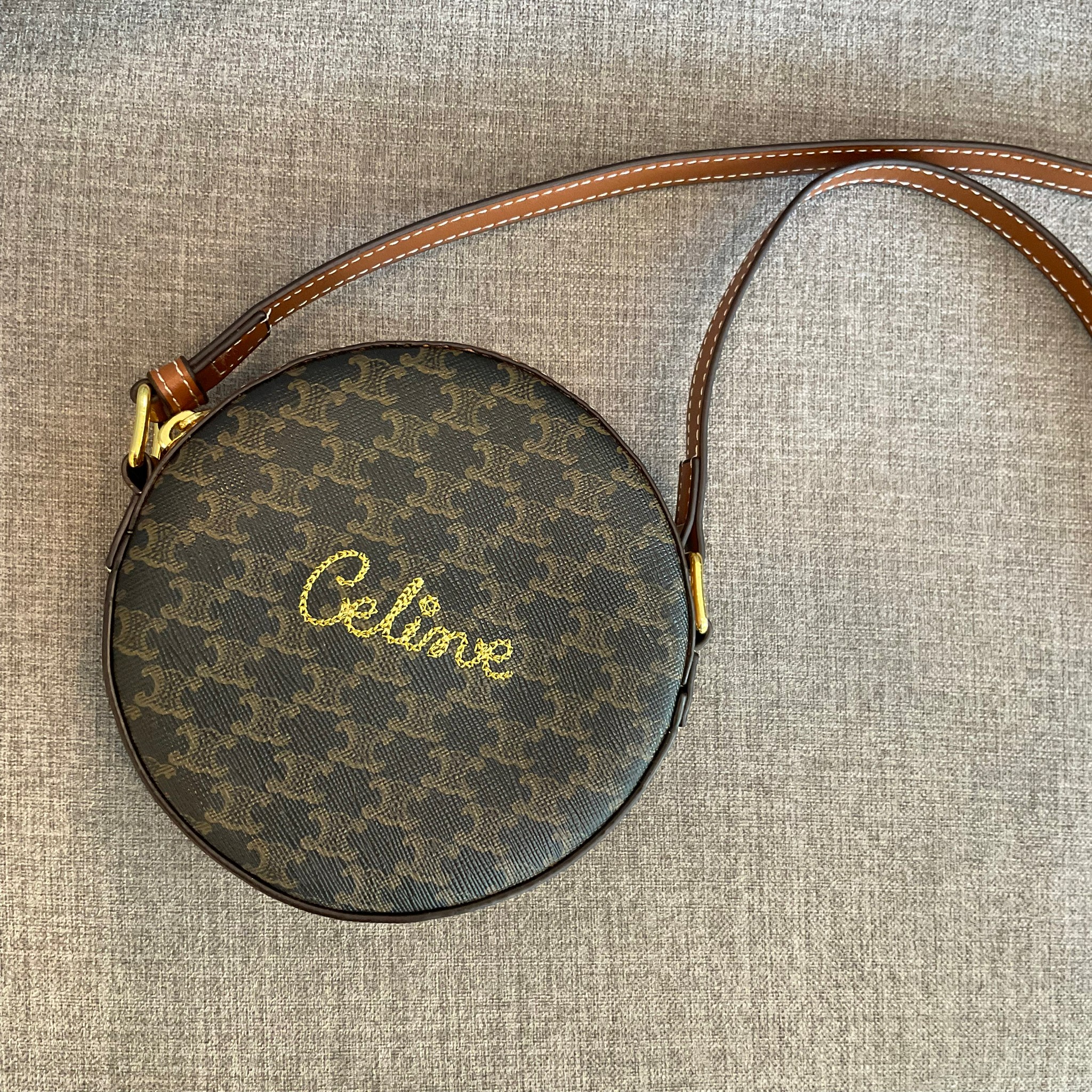 CELINE ROUND PURSE ON STRAP IN TRIOMPHE CANVAS / พร้อมส่งที่ไทยกับ CELINE CROSSBODY BAG กระเป๋าทรงครอสบอดี้ ใบกลมเล็กน่ารัก วัสดุหนังทั้งใบ ตกแต่งด้วยโลโก้แบรนด์ปักเลื่อมด้านหน้า