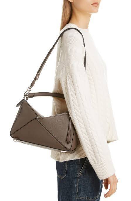 Loewe Puzzle Bag In Classic กระเป๋าทรง Puzzle นี้ออกแบบโดย Jonathan Anderson โดยได้รับแรงบันดาลใจในการออกแบบมาจากรูปทรงของลูกรักบี้ ดังนั้น จึงจะเห็นได้ว่าการตัดเย็บและรูปทรงของกระเป๋านั้นคล้ายคลึงกับลูกรักบี้ รูปทรงดูมินิมอลไม่ทิ้งคอนเซ็ปต์ของแบรนด์ สามา