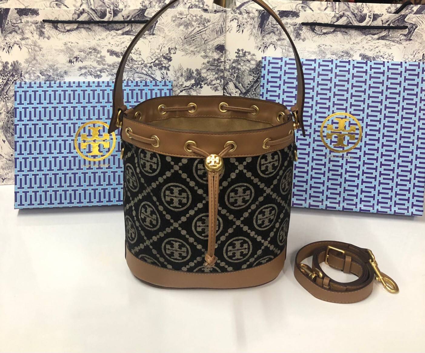 Medium : Tory Burch T Monogram Chenille Bucket Bag เปิดตัวอีกหนึ่งรุ่นกับกระเป๋าลาย T MONOGRAM รุ่นใหม่ล่าสุดจาก TORY BURCH พลาดไม่ได้กับโลโก้สุดคลาสสิก ลวดลาย T Monogram คือวัสดุ chenille หรือที่เรียกว่า ด้านไหมกำมะหยี่ มารังสรรค์ลงบนกระเป๋าBucketใบนี้ เ