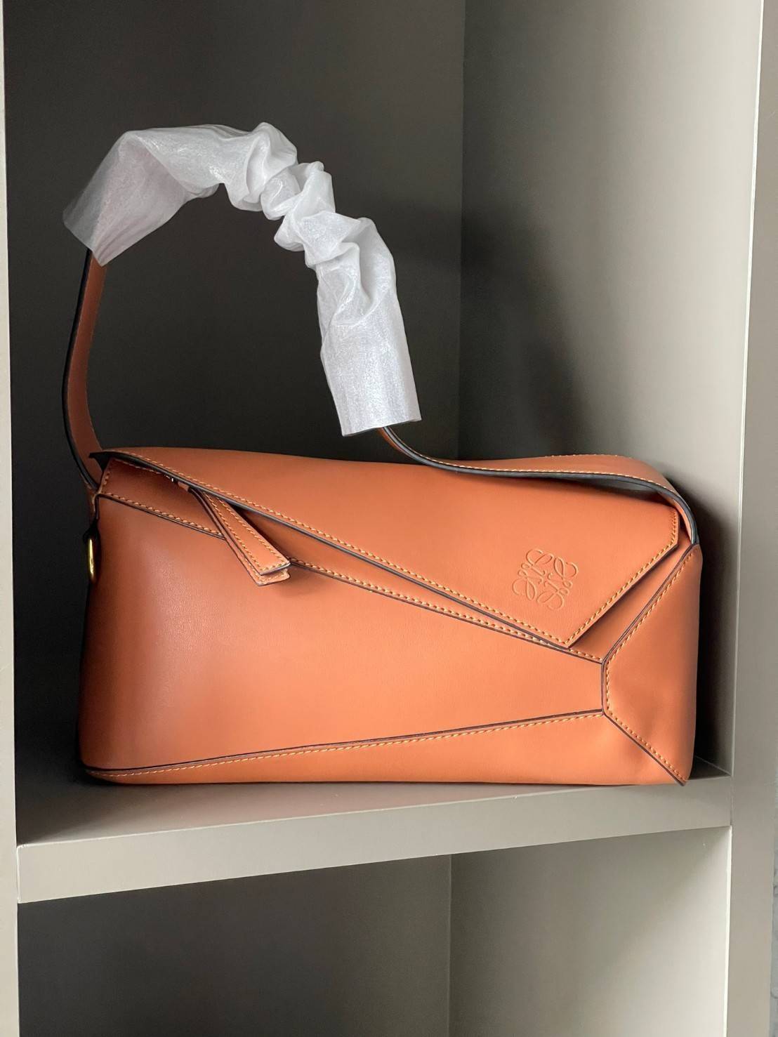 Loewe Puzzle Hobo bag กระเป๋ารุ่น Puzzle มีความพิเศษในหลายด้าน ไม่ว่าจะเป็นรูปทรงที่แปลกใหม่ มินิมอลด้วยโลโก้อนาแกรมแบบประทับ ดูหรู เป็นกระเป๋า Unisex ที่ไม่ว่าคุณจะเป็นผู้หญิงหรือผู้ชายก็ใช้งานได้ ลายกระเป๋าได้มาจากการนำหนังมาเย็บต่อกันทั้งหมด ถึงแม้ว่าข