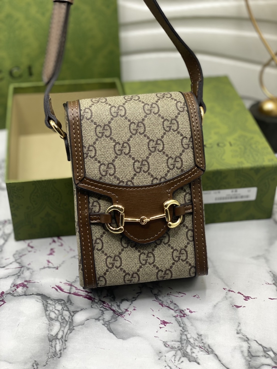 หนังแท้ GUCCI Horsebit phone bag กระเป๋าสะพาย กระเป๋าใส่โทรศัพท์สุดคลาสสิก หนังวัวแท้สีน้ำตาล/สีขาว อะไหล่ทองสวย ดีไซต์สัญลักษณ์วงแหวนตามแบบฉบับแบรนด์ สายสะพายยาวที่สามารถปรับระดับได้ ภาพสินค้าถ่ายจากงานขายจริง ใช้งานต่างประเทศได้ค่ะ