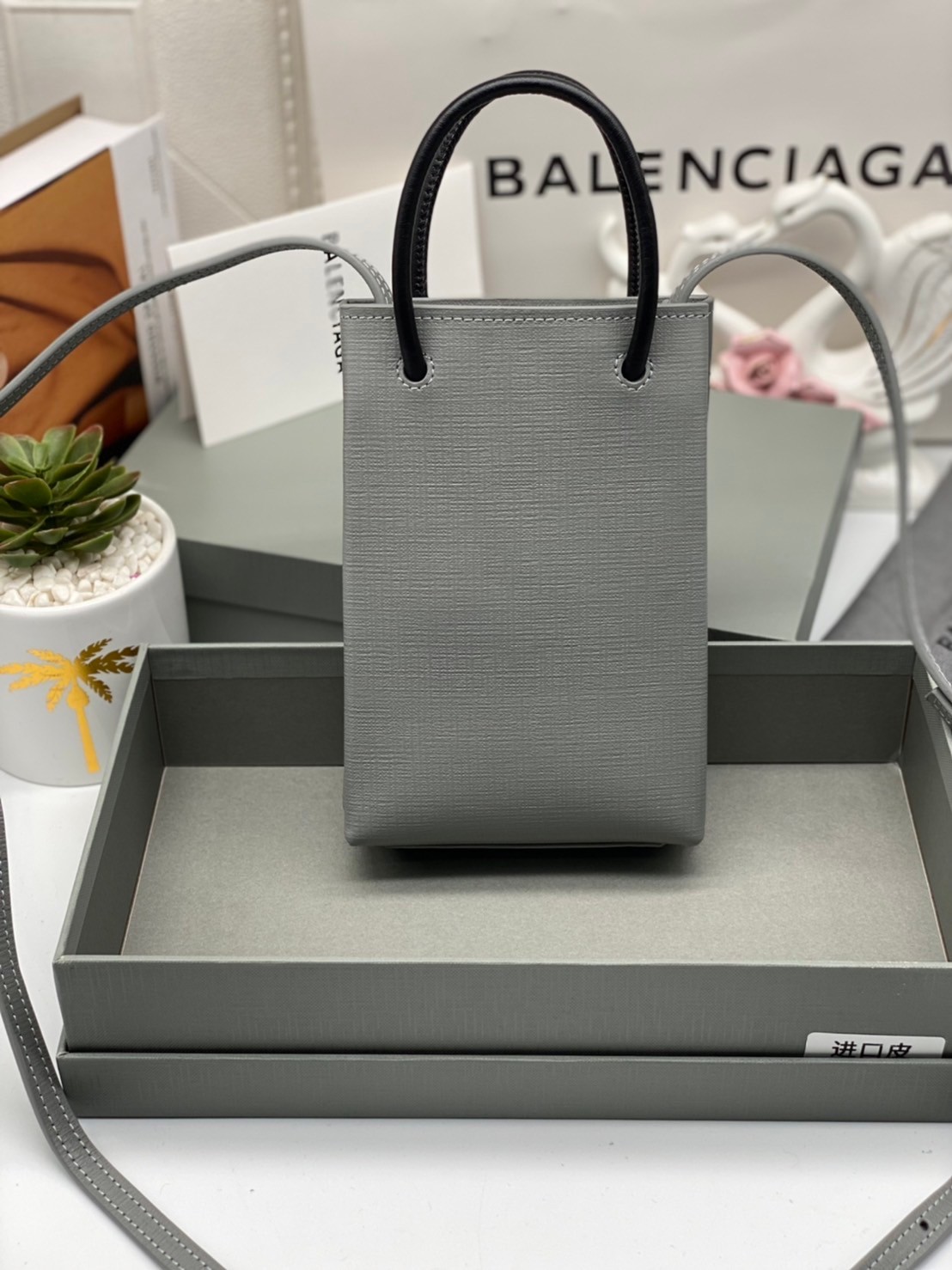 หนังแท้ BALENCIAGA Shopping Phone Pouch leather tote พกกระเป๋าช้อปปิ้งขนาดมินิ ไปทุกที่ในฤดูกาลนี้ ดีไซน์ที่ใช้ได้ทุกวันตั้งแต่หนังแบบมีเท็กซ์เจอร์ ภาพสินค้าถ่ายจากงานขายจริง ใช้งานต่างประเทศได้