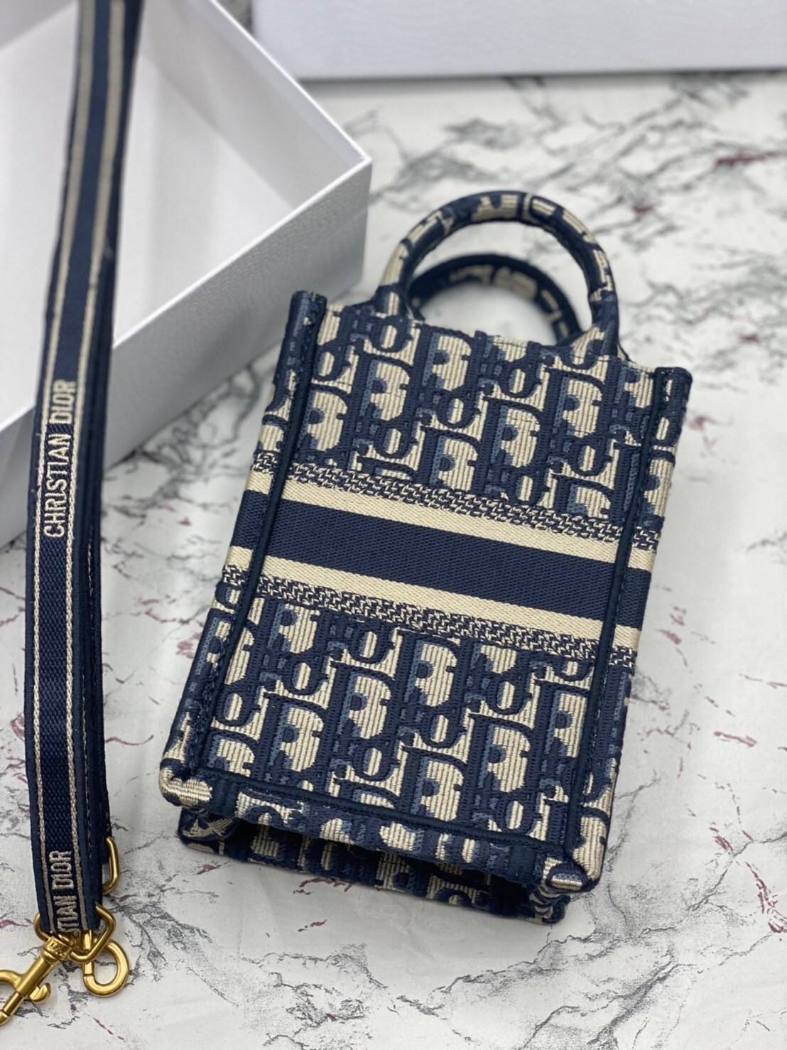 ORI 】Mini Dior Book Tote Phone Bag Blue Dior Oblique Embroidery พร้อมส่งที่ไทย ภาพสินค้าถ่ายจากงานขายจริง ใช้งานต่างประเทศได้ กระเป๋าใบมินิจะใส่โทรศัพท์ได้เช่นเดียวกับของใช้จำเป็นเล็กๆ น้อยๆ ในแต่ละวัน มาพร้อมสายสะพายไหล่แบบปักที่ปรับได้และถอดออกได้ อุปกร
