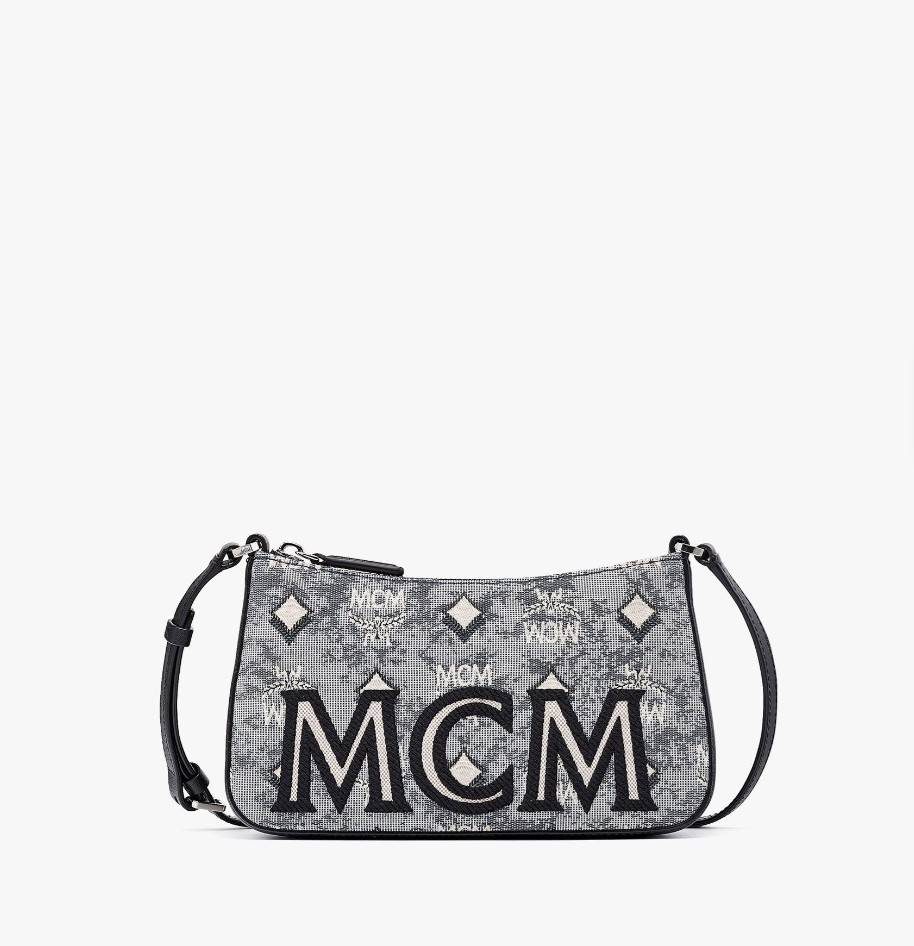 M.C.M MINI SHOULDER BAG IN VINTAGE JACQUARD MONOGRAM คอลเลคชั่นใหม่ล่าสุด โดดเด่นด้วยลายโมโนแกรม ถักทอบนผ้า woven jacquard กระเป๋าสะพายทรงพอชที่ไม่ธรรมดา มาพร้อมสายสะพายในตัว สามารถปรับใช้ได้ 2 แบบ สายยาวสะพายข้าง หรือจะนำสายเส้นกลางออกและปรับใช้สะพายไหล่