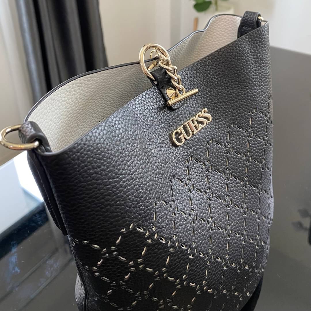 Guess Amara Bucket Handbag ซื้อ 1 ได้ถึง 2 กระเป๋ารุ่นใหม่ล่าสุดทรงถังสุดน่ารัก พิมพ์ลายรอบใบ วัสดุหนังนิ่มคุณภาพดี นิ่ม น้ำหนักเบา ด้านหน้าประดับด้วยโลโก้แบรนด์สวยโดดเด่น เปิด-ปิดด้วยด้วยตัวคล้องอะไหล่เงินสะดวกใช้ ด้านในโล่ง มีสายยาวปรับระดับได้มาให้ มาพ