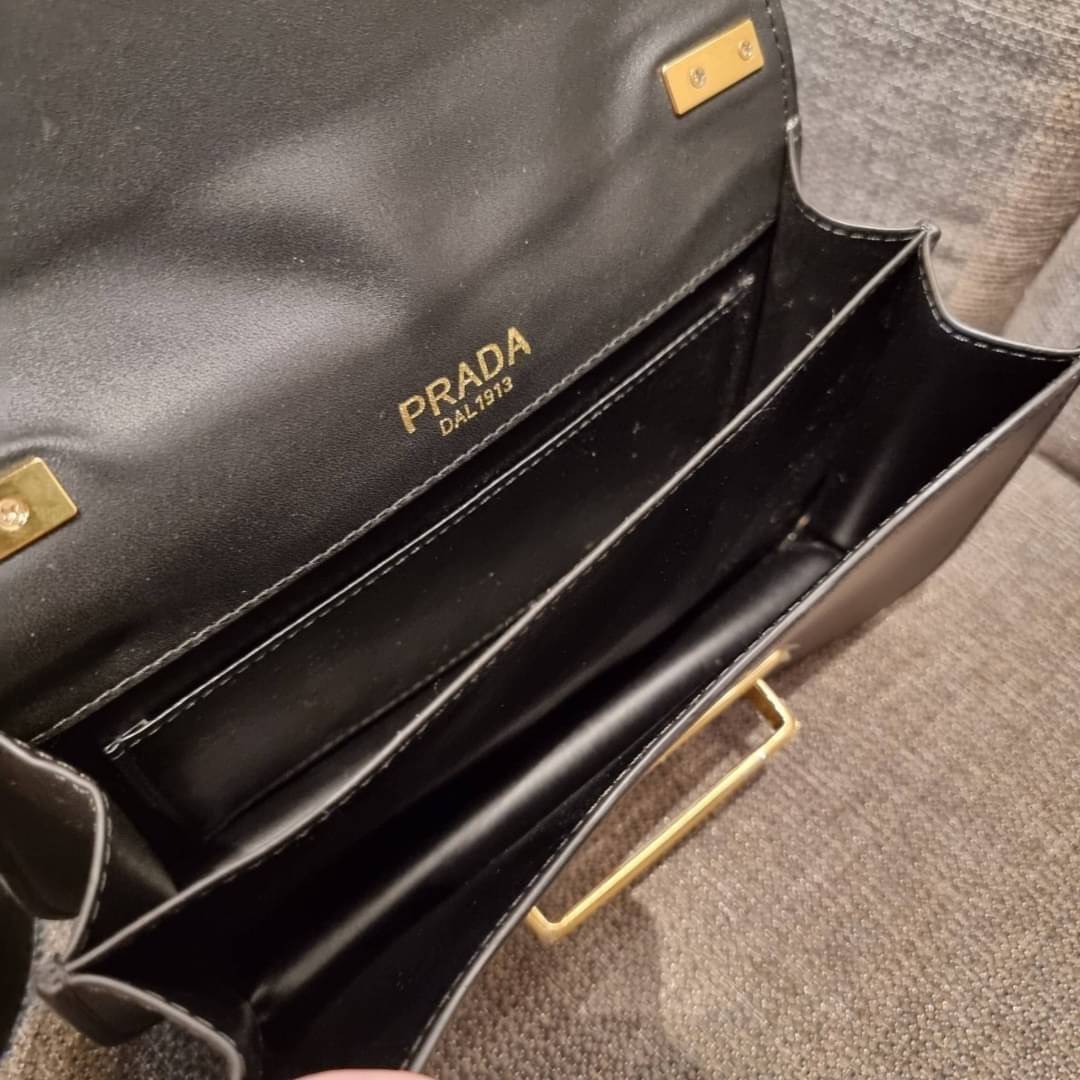 PRADA FRAGRANCE SHOULDER BAG WITH GWP ไอเท็มสุดโปรดที่ควรค่าแก่การครอบครองและเก็บสะสม กระเป๋าสะพายไหล่ สวยคม สีดำคลาสสิคตัดกับอะไหล่ทองเป็นอย่างดี วัสดุหนังแท้เต็มใบ เปิดปิดด้วยแถบหนังสอดในช่อง ใช้งานสะดวก พกพาง่าย ขนาดกำลังสวย สายสะพายในตัว สะพายได้หลากห