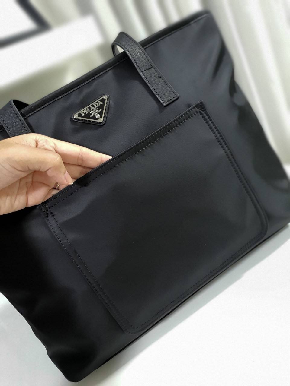 งานพรีเมี่ยมกิ้ฟท์แบรนด์ดังอย่าง PRADA NYLON กับรุ่น TOTEBAG กระเป๋าสะพายไหล่ ใบนี้วัสดุเป็น NYLON กันน้ำทั้งใบมาพร้อมอะไหล่สีเงิน ด้านหน้ามีช่องแยกใส่ของและประดับด้วยโลโก้แบรนด์สวยหรู ภายในมีช่องซิปแยก1ช่อง สามารใส่ A4 ipad ได้ทุกรุ่น ใบเดียวใช้ได้ทุกโอก