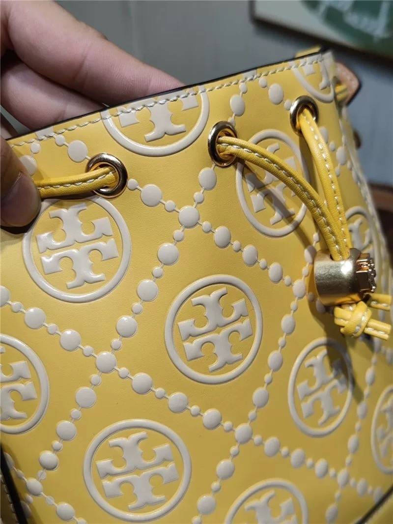 Medium : Tory Burch T Monogram Embossed Bucket Bag กระเป๋าถือหรือสะพายไหล่ ประดับด้วยลวดลายอันเป็นสัญลักษณ์ของแบรนด์ ถูกประดิษขึ้นด้วยความพิถีพิถันวัสดุหนังอย่างดี ด้านในบุด้วยหนังไมโครซูแอคเนื้อนุ่มทำความสะอาดง่าย กระเป๋าผ่าหลังด้านนอก1ช่อง ด้านใน 1ช่อง 