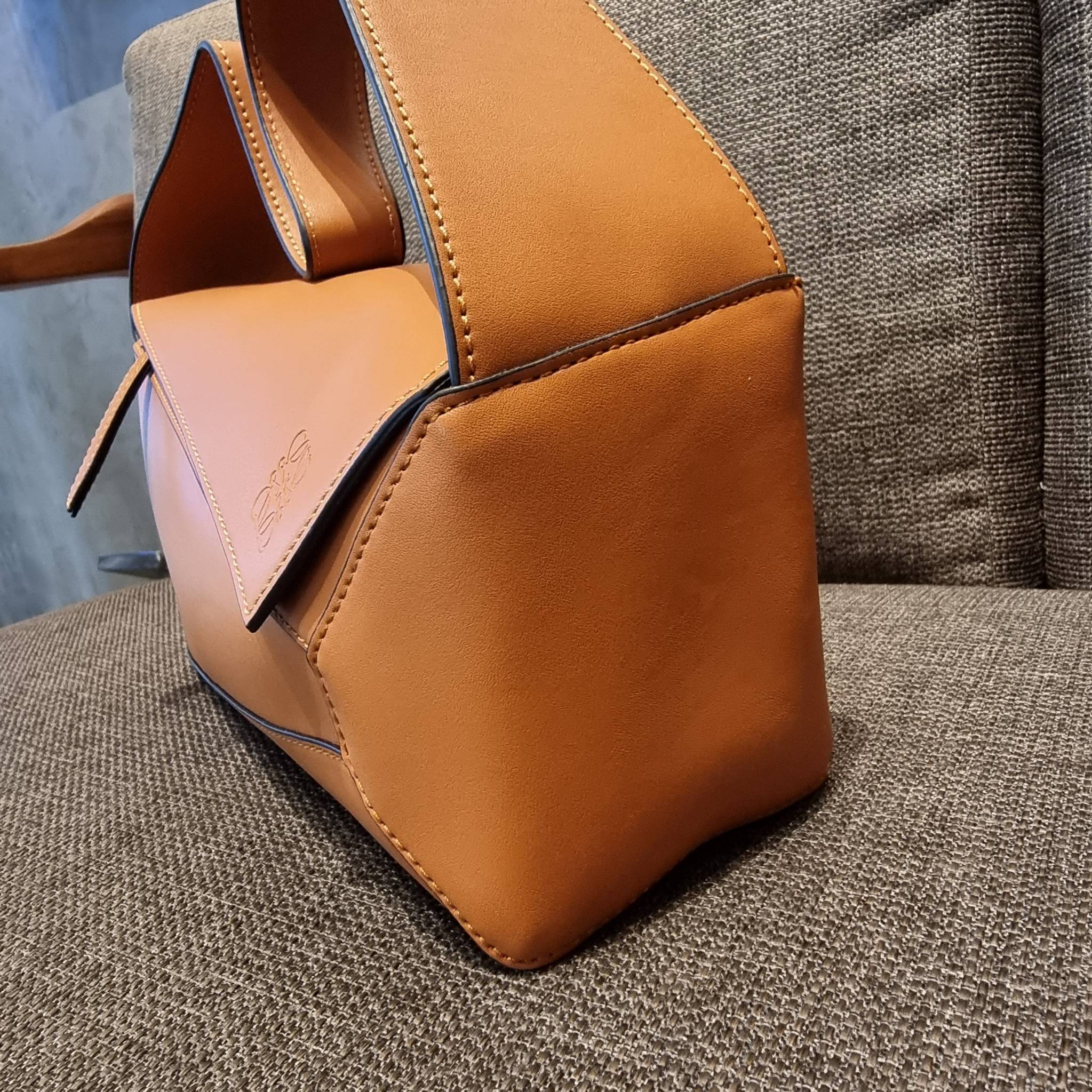 LOEWE PUZZLE HOBO BAG ใหม่ล่าสุด กับแบรนด์ที่มีดีไซน์โดดเด่นเป็นเอกลักษณ์ สวยหรูทุกรุ่นจริงๆ!! กระเป๋าสะพายโฮโบ ทรงสวย สไตล์พัซเซิลคลาสสิค วัสดุหนังวัวฟอกสี นิ่มมือ ฟินมาก!! เปิดใช้งานด้วยซิป ที่ภายในโล่งกว้าง ใส่ของสำคัญได้ครบไม่มีพลาด แบบสบายๆ มาพร้อมสา