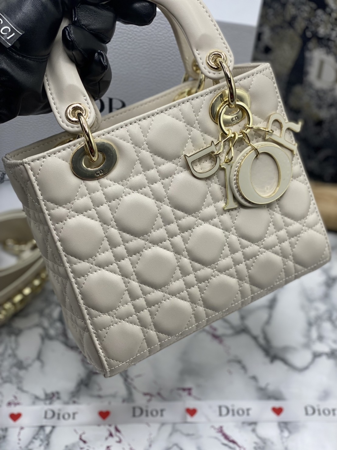 หนังแท้ DIOR LADY BAG 20cm ความสง่างามอีกหนึ่งรุ่นของ Dior รูปทรงสีเหลียม ขนาดกระทัดรัด ตั้งอยู่ทรง ฐานกระเป๋าแข็งแรง มีหมุดรองฐาน ดีไซน์ที่มีเอกลักษณ์เฉพาะตัว ด้านหน้าตกแต่งด้วยตัวอักษร D.I.R ห้อยเป็นพวงกุญแจ จะถือด้วยมือหรือสะพายไหล่ก็ดูดีมากๆ ค่ะ