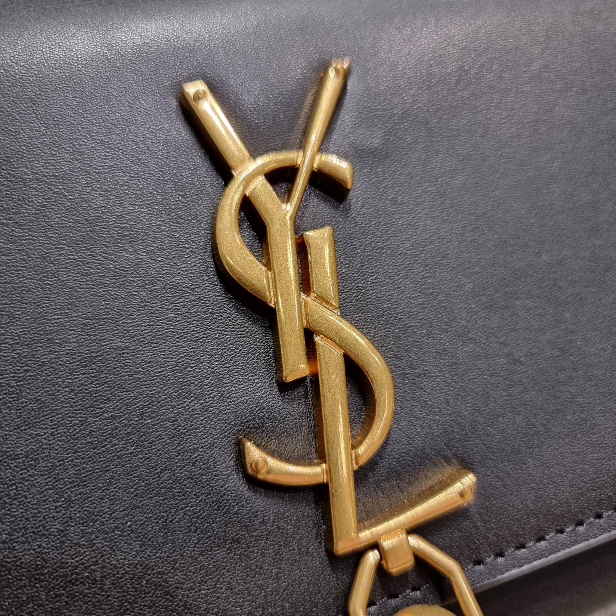 Yves Saint laurent small kate bag สุดหรู ทรง woc ที่แสนจะฮอตปรอทแตก ดีไซน์เรียบ แต่แอบมีดีเทลความหรูที่พู่ห้อยสีทองโดดเด่น เพิ่มความแพงอีกหนึ่ง วัสดุหนังแท้สัมผัสดีงาม ใช้งานง่ายเพียงแค่เปิด-ปิดด้วยกระดุมแม่เหล็ก ภายในเป็นช่องโล่ง มีช่องใส่บัตร ใส่มือถือ 