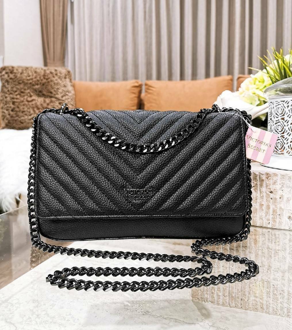 VICTORIA'S SECRET Quilted Chain Crossbody Sling Bag กระเป๋าสะพายรุ่นใหม่ล่าสุดจาก Victoria's Secret วัสดุหนังแกะสังเคราะห์ชึ้นลายริ้วหนังสวยอยู่ทรงไม่ย้วยดีไซน์สุดหรูคุณหนูไฮโซ เปิดปิดด้วยฝาปิดกระดุมแม่เหล็ก ภายในมีโลโก้และช่องใส่ของ ใส่กระเป๋าส