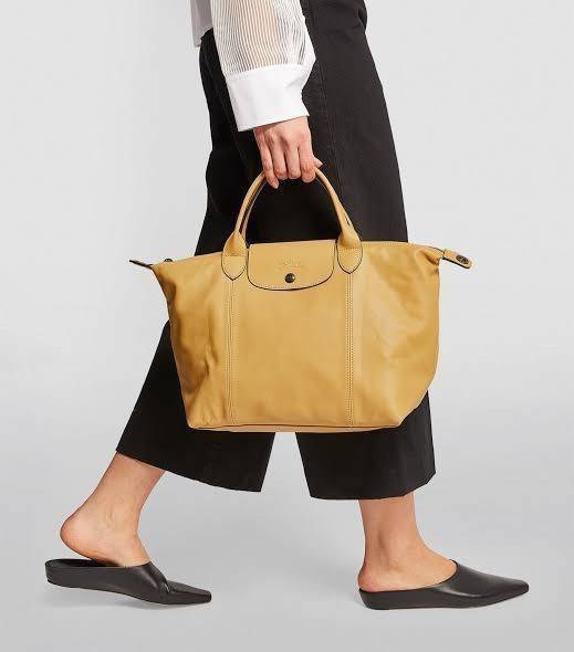 Longchamp Le Pliage Cuir Top handle bag S เรียกว่าเป็นกระเป๋าอีกหนึ่งรุ่นที่ไม่ว่ายังไงก็ฮอตฮิตและติดเทรนด์ตลอดไม่เคยเปลี่ยนกับ ทรง Le Pliage Cuir หนึ่งในตระกูลกระเป๋าสุดไอคอนิกจากแบรนด์
