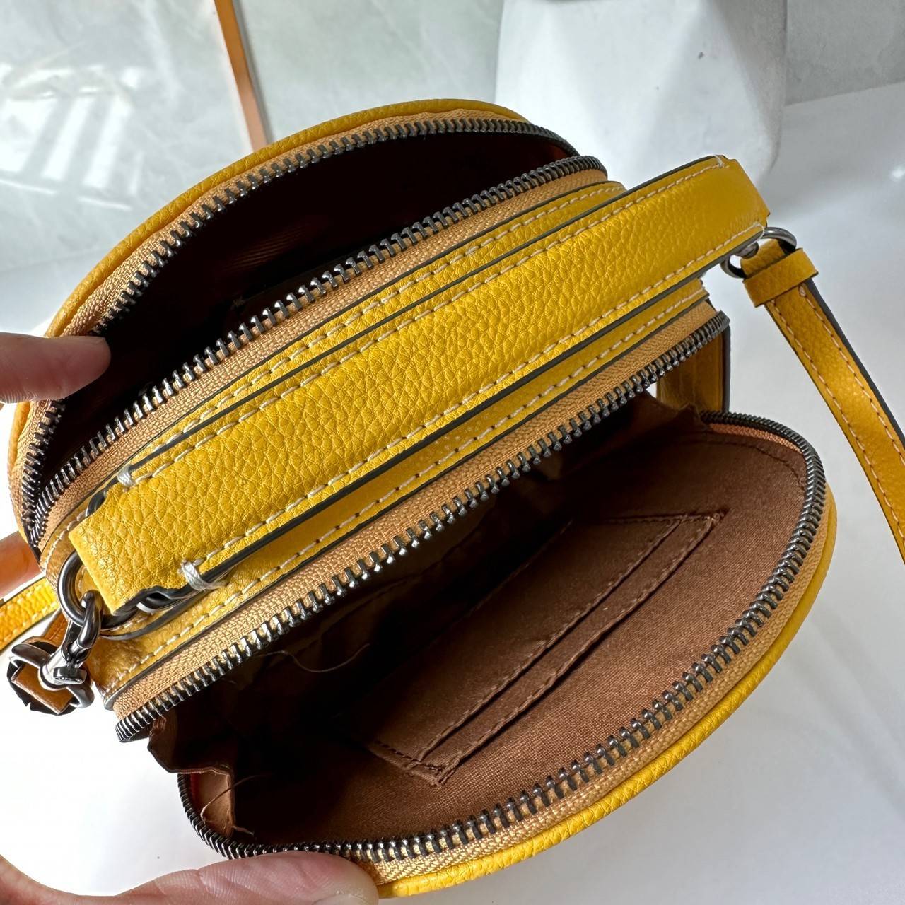 COACH X PEANUTS CANTEEN CROSSBODY WITH SNOOPY PRESENT MOTIF (CE845,CF290) กระเป๋าสะพายข้างทรงกลมไซส์มินิ มีหูจับ วัสหนังแท้ ด้านหน้าโดดเด่นด้วยรูปการ์ตูนSnoopy