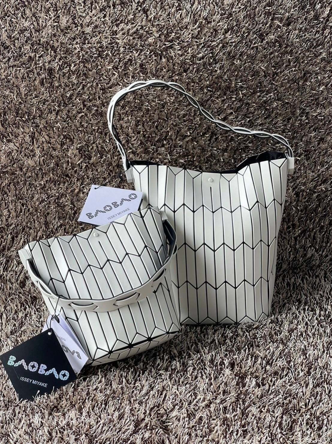 Large : Baobao Issey Miyake Large Bucket กระเป๋าบัคเก็ตขนาดใหญ่สามารถใช้ใส่ร่มพับได้หรือขวดน้ำขนาดเล็กได้ ซีรีย์ใหม่นี้มีจุดเด่นที่แผ่นรูปทรงสี่เหลี่ยมด้านขนานในแนวตั้ง เกิดเป็นรูปทรงสามมิติซึ่งแตกต่างไปจากรูปทรงที่เกิดขึ้นจากแผ่นสามเหลี่ยม หูหิ้วสามารถขย