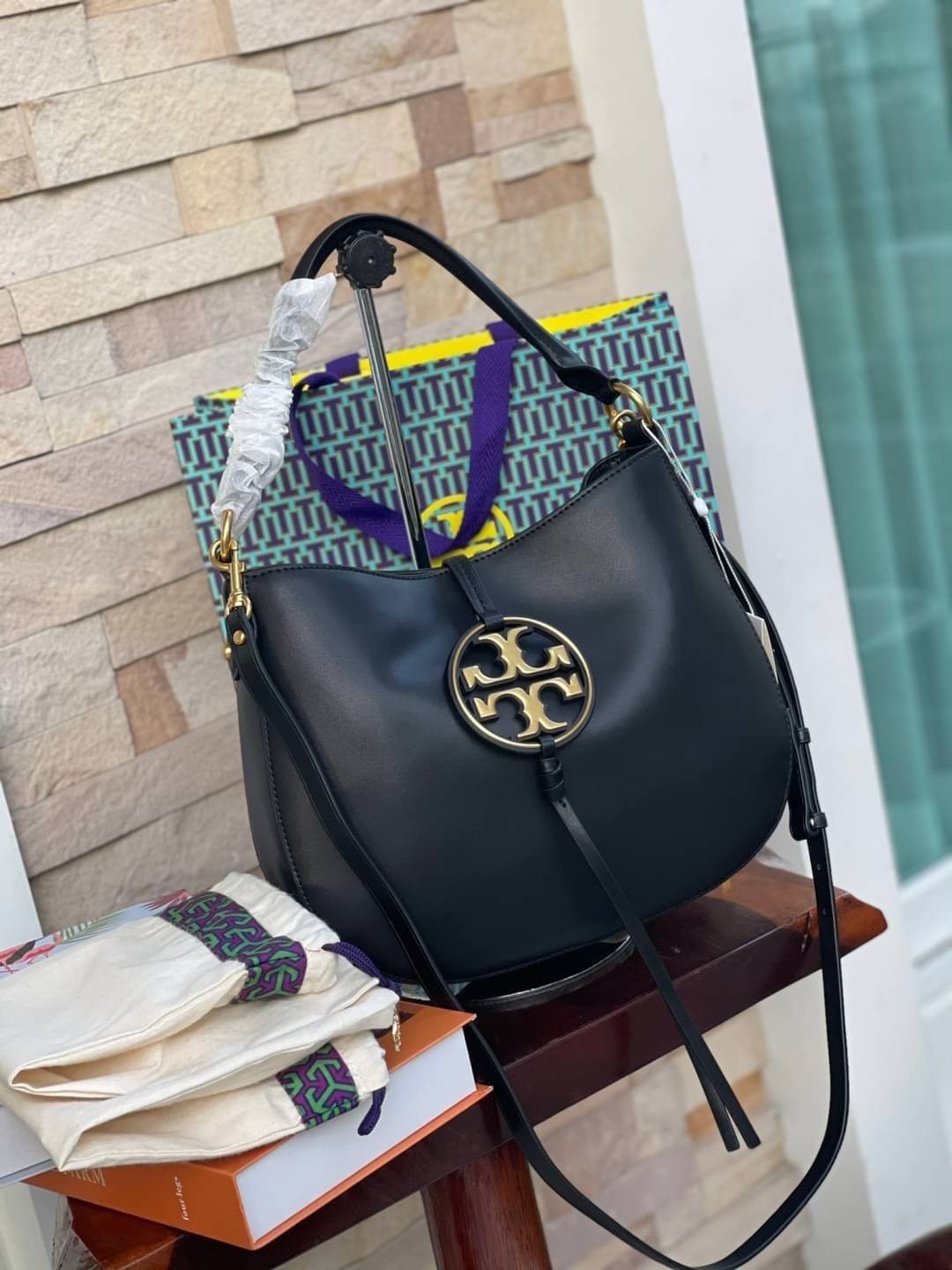 Tory burch miller metal-logo mini hobo bag มีกลิ่นอายสุดคลาสสิก ได้รับแรงบันดาลใจมาจากการขี่ม้า จึงได้ดีไซน์กระเป๋าออกมาในรูปแบบอานหลังม้าสุดเก๋ที่สามารถนำไปมิกซ์แอนด์แมทช์กับสไตล์การแต่งตัวได้หลายชนิด ไม่ว่าจะเป็นกับเดรสทรงยาวหรือกางเกงยีนแสนเท่ตัวโปรดขอ