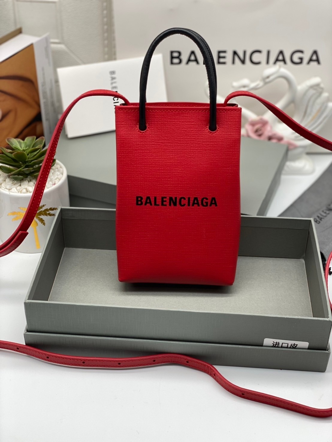 หนังแท้ BALENCIAGA Shopping Phone Pouch leather tote พกกระเป๋าช้อปปิ้งขนาดมินิ ไปทุกที่ในฤดูกาลนี้ ดีไซน์ที่ใช้ได้ทุกวันตั้งแต่หนังแบบมีเท็กซ์เจอร์ ภาพสินค้าถ่ายจากงานขายจริง ใช้งานต่างประเทศได้