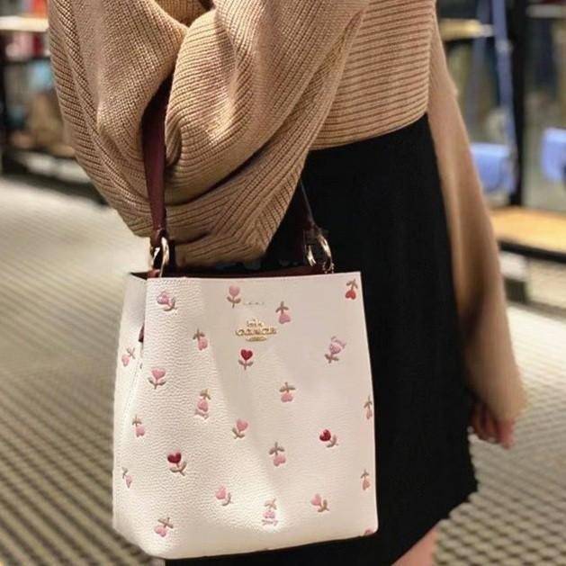 OUTTLET 】COACH SMALL TOWN BUCKET BAG IN SIGNATURE WITH Heart floral print สำหรับสาวแฟชั่นที่ชอบรายละเอียดชิคๆ ดีไซน์สุดเก๋ แนะนำเลยสำหรับกระเป๋าทรงบักเก็ตใบนี้ เชื่อว่าสาว ๆ หลายคนชื่นชอบ เป็นไอเทมที่สามารถแมทช์ได้กับเสื้อหลากหลายสไตล์ บรรจุของได้เยอะโดยท