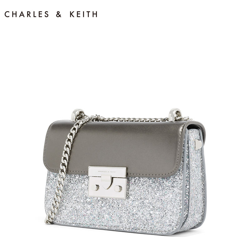 CHARLES & KEITH Mini Square Shaped shoulder bag กระเป๋าสะพายไซส์มินิประดับด้วยกากเพชรวิ้งๆ ติดแน่น อะไหล่ทอง สายสะพายโซ่ ตัวล็อคแบบ บีบดันปลดล็อค ใช้งานง่าย ด้านในมี 3 ช่อง มีช่องซิปด้วย ด้านข้าง ประดับหมุดทรงนูนเหลี่ยม ใส่ iphone+ได้ สบาย ๆ สวยระยิบระยับ