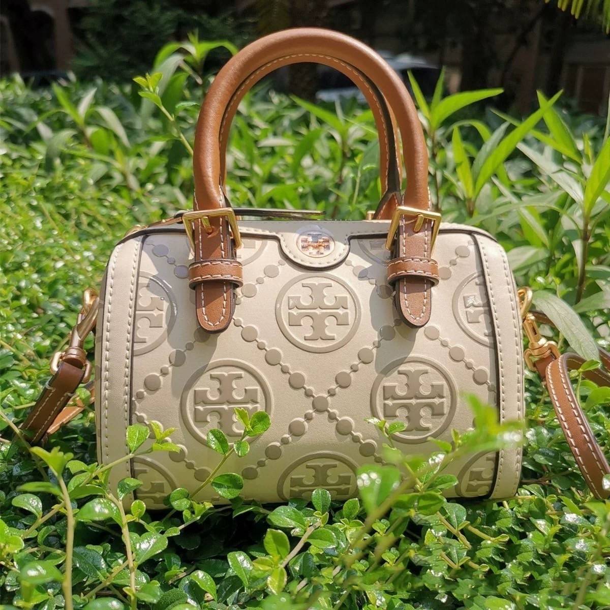 Tory Burch T-Monogram Mini Embossed Wine Bucket Bag / Tory Burch Mini Bucket กระเป๋าถือหรือสะพายไหล่ ทรงหมอนขนาดเล็ก ประดับด้วยลวดลายอันเป็นสัญลักษณ์ของแบรนด์ ถูกประดิษขึ้นด้วยความพิถีพิถันวัสดุหนังอย่างดี ด้านในบุด้วยหนังไมโครซูแอคเนื้อนุ่มทำความสะอาดง่า