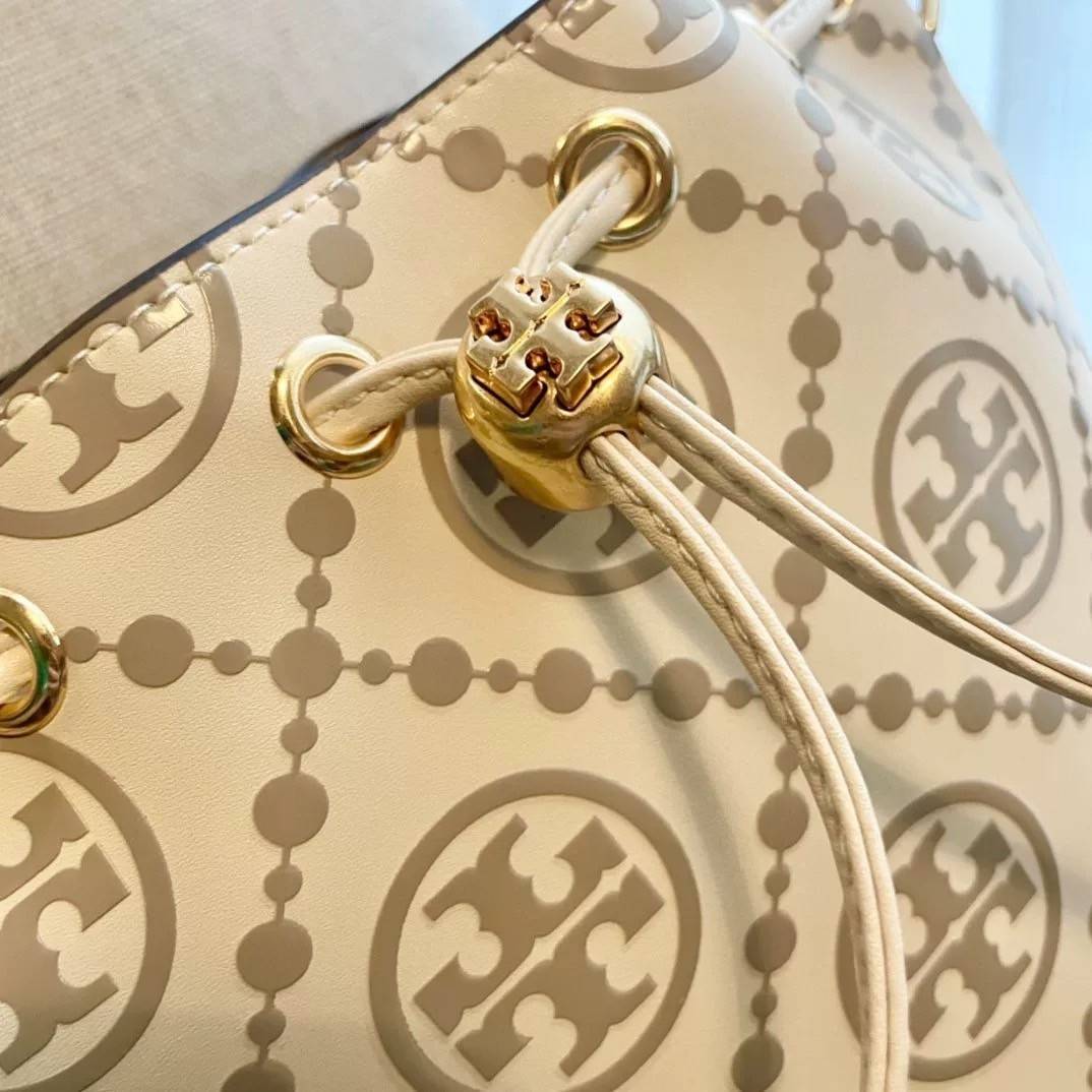 Medium : Tory Burch T Monogram Embossed Bucket Bag กระเป๋าถือหรือสะพายไหล่ ประดับด้วยลวดลายอันเป็นสัญลักษณ์ของแบรนด์ ถูกประดิษขึ้นด้วยความพิถีพิถันวัสดุหนังอย่างดี ด้านในบุด้วยหนังไมโครซูแอคเนื้อนุ่มทำความสะอาดง่าย กระเป๋าผ่าหลังด้านนอก1ช่อง ด้านใน 1ช่อง 