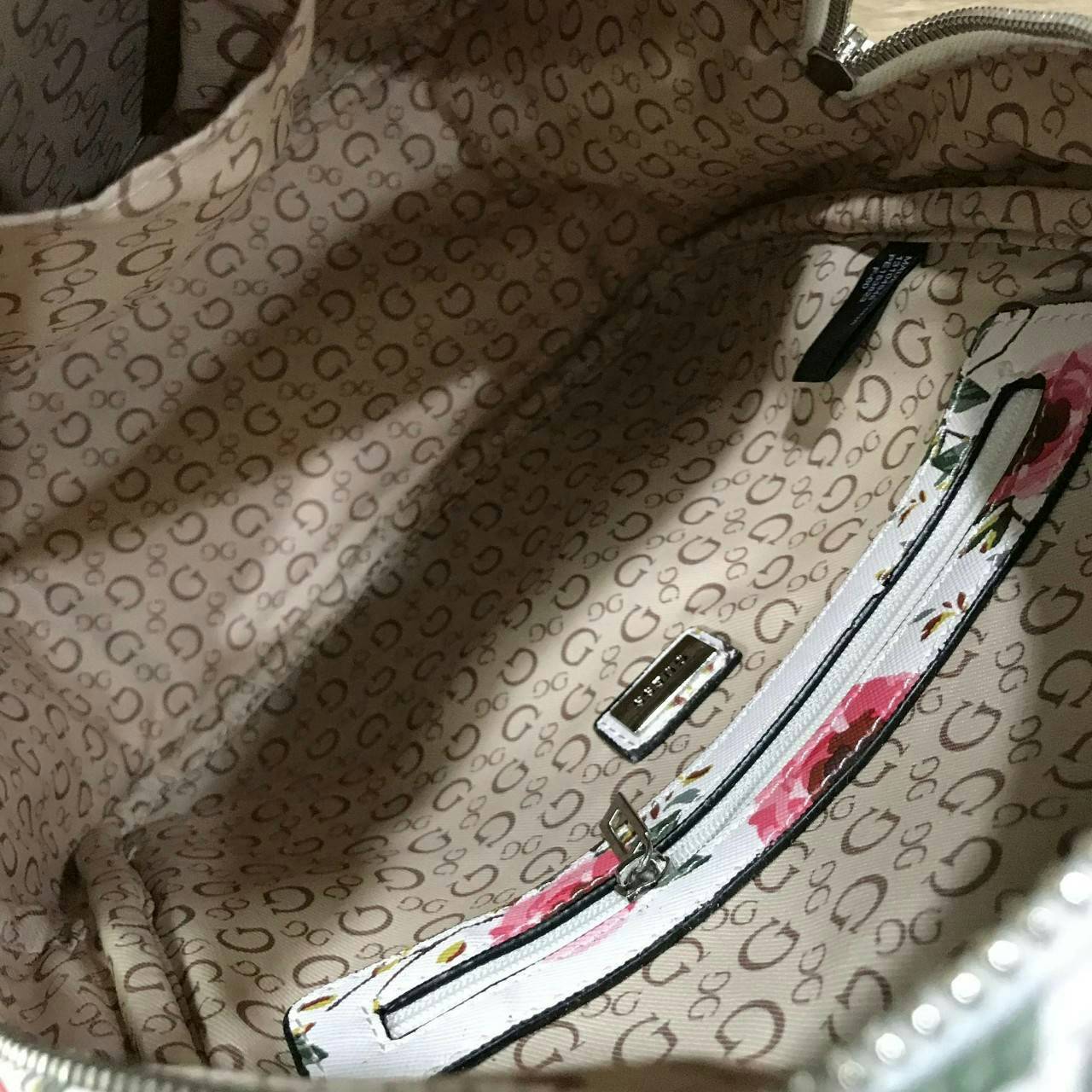 GUESS WOMAN'S FACTORY BACKPACK กระเป๋าเป้รุ่นใหม่ล่าสุดขนาดกำลังดีวัสดุหนังแกะสังเคราะห์พิมพ์ลายดอกไม้สวยน่ารัก น้ำหนักเบา มีหูหิ้วเเละสายสะพายหลังเลื่อนปรับได้ ด้านหน้ามีโลโก้และช่องซิป เปิดปิดด้วยซิปสะดวกใช้ ภายในกว้างและจุ ใส่ ipad กระเป๋าสตางค์ใบ