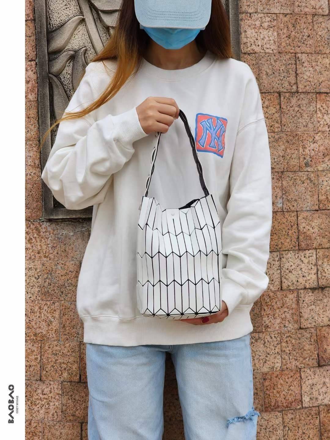 Large : Baobao Issey Miyake Large Bucket กระเป๋าบัคเก็ตขนาดใหญ่สามารถใช้ใส่ร่มพับได้หรือขวดน้ำขนาดเล็กได้ ซีรีย์ใหม่นี้มีจุดเด่นที่แผ่นรูปทรงสี่เหลี่ยมด้านขนานในแนวตั้ง เกิดเป็นรูปทรงสามมิติซึ่งแตกต่างไปจากรูปทรงที่เกิดขึ้นจากแผ่นสามเหลี่ยม หูหิ้วสามารถขย