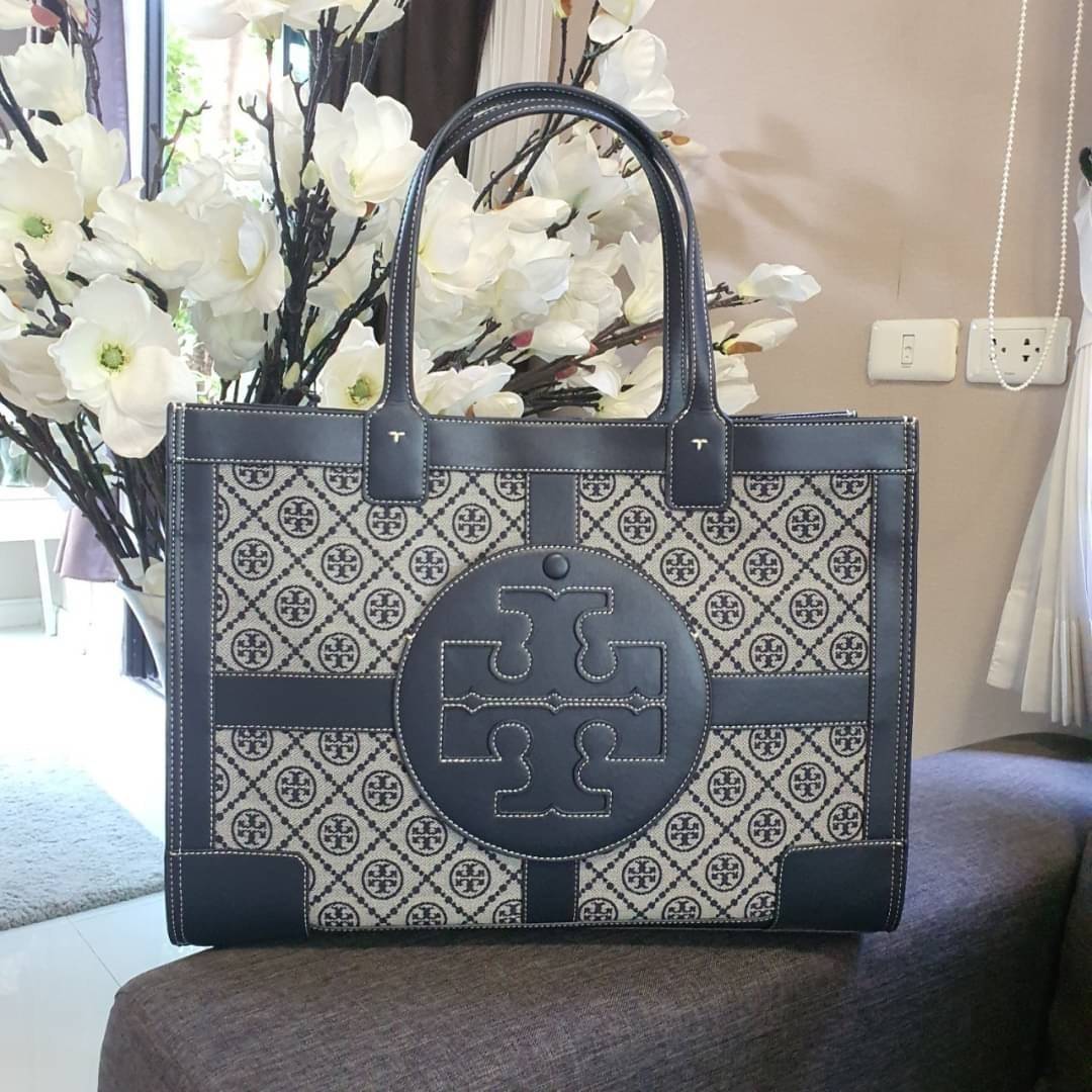 OUTTLET 】TORY BURCH TOTE BAG วัสดุ CANVAS ทั้งใบตัดด้วยหนังแท้สี NAVY ตัวกระเป๋าตั้งอยู่ทรงสวย แต่งโลโก้แบรนด์ด้านหน้า ด้านข้างมีกระดุม สามารถขยายทรงได้ ด้านในเปิดปิดด้วยกระดุมแม่เหล็ก ช่องกว้างหลักหนึ่งช่องและช่องซิปอีกช่อง สามารถใส่กระเป๋าสตางค์ยาว สมุด