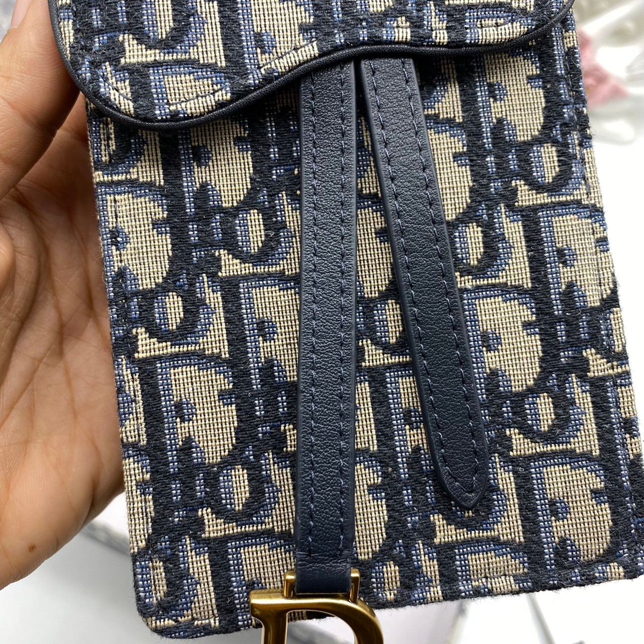 หนังแท้ DIOR PHONE BAG / DIOR PHONE HOLDER BAG กระเป๋าใส่โทรศัพท์เอกลักษณ์ของความหรู สายสะพายโซ่อะไหล่ทอง วัสดุหนังแท้และผ้า Jacquard อย่างดีสวยงามที่สุด ผสมผสานความสง่างามและคลาสสิกที่เข้ากับยุคสมัย ด้านหน้าโดดเด่นด้วยซิกเนเจอร์แบรนด์ เป็นอีกหนึ่งรุ่นที่