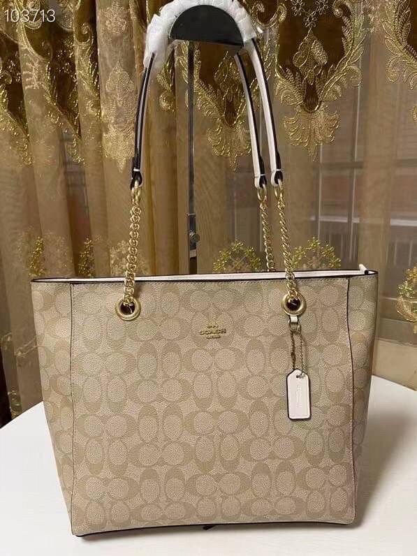 COACH Tote in Signature Canvas Bag กระเป๋าสะพายทรงช้อปปิ้ง สายกระเป๋าเป็นหนังสลับโซ่ทองสวยงาม เพิ่มความหรูหรา ภายในโล่งกว้างใส่ของได้เยอะมาก วัสดุ Canvas เคลือบลายซิกเนเจอร์และหนัง พร้อมซิปกลางเก็บของได้มิดชิดเลยค่ะ มี 3 สี น้ำตาล ดำ ขาว