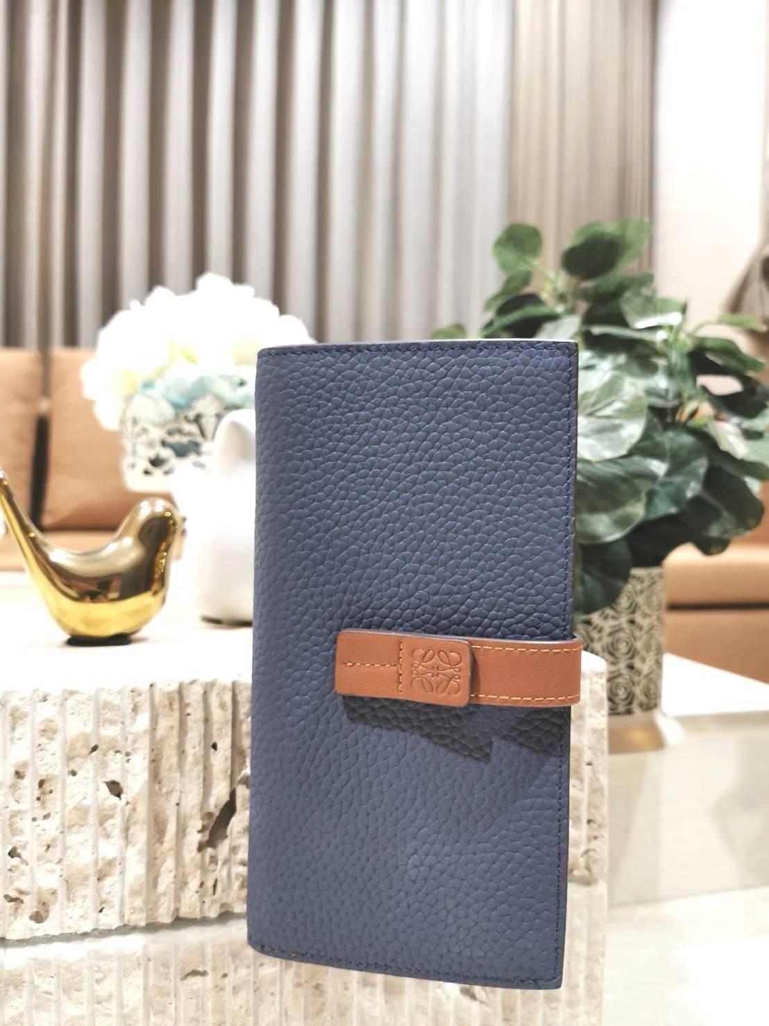 LOEWE LONG WALLET BAG วัสดุหนังแท้เทคเจอร์สวยอยู่ทรงปั้มโลโก้แบรนด์ด้านหน้าเปิดปิดด้วยกระดุม ภายในมีช่องใส่ธนบัตรหลายช่อง ช่องหลักสามารถใส่มือถือได้ มีช่องซิปใส่เหรียญ ช่องใส่ธนบัตรใส่แบงก์พันได้ สวยน่าใช้ พร้อมส่งที่ไทยสุดคุ้มห้ามพลาด!